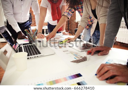 Teamwork,brainstorming concept.Young creative managers team working with new startup project in modern office. Contemporary notebook on wood table.Horizontal