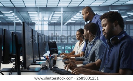 Teamworking computer scientists talking in server room, developing disaster recovery plans. Team of data center office coworkers doing brainstorming, monitoring metrics across devices