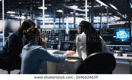 Teamworking data center technicians using machine learning algorithms to analyze large datasets. Server room colleagues gathered together at desk, collaborating, using AI neural networks, camera A