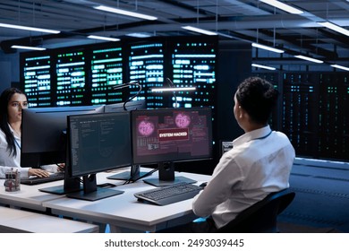 Teamworking developers in server room trying to protect hardware from cybercriminal attack. Data center cybersecurity division colleagues fighting malware during security breach