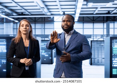 Teamworking engineers in server room using AR tech to implement and maintain security measures, protecting systems from unauthorized access. Data center colleagues using augmented reality