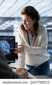 Teamworking engineers using artificial intelligence technology to optimize data center workplace. Colleagues talking in server hub, using AI tech to streamline operations and forecast issues
