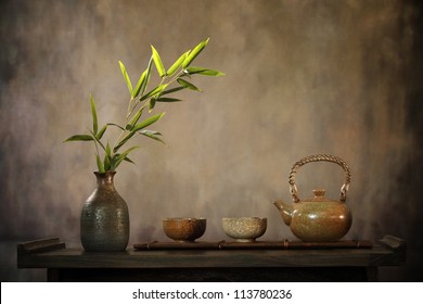Teapot and bamboo leaves on table. - Shutterstock ID 113780236