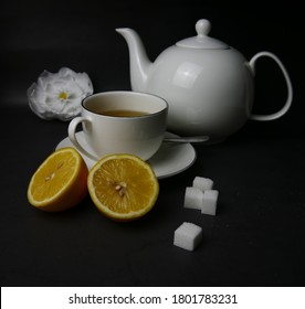 teapot, cup of tea, sugar cubes and lemon