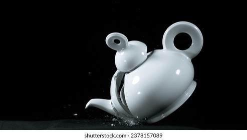 Tea-Pot falling and exploding on Black Background