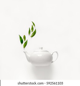 Teapot of fresh green tea with green leaves rising above, tea aromatic qualities concept