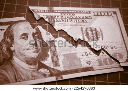 Tear off US dollar bill banknote as chart graph falling down. The Federal Reserve ( FED ) increase % interest rates to fix inflation crisis. World global economy recession and stagflation concept.