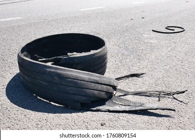 Tear rubber truck tire on asphalt road highway. Defect broken tire.