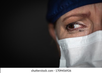Médica o enfermera cansada usando una máscara médica de fondo oscuro.