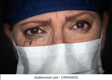 Tearful Stressed Female Doctor Or Nurse Wearing Medical Face Mask On Dark Background.