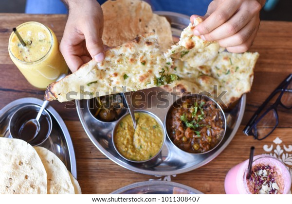Tearing Apart Naan\
Bread at Indian\
Restaurant