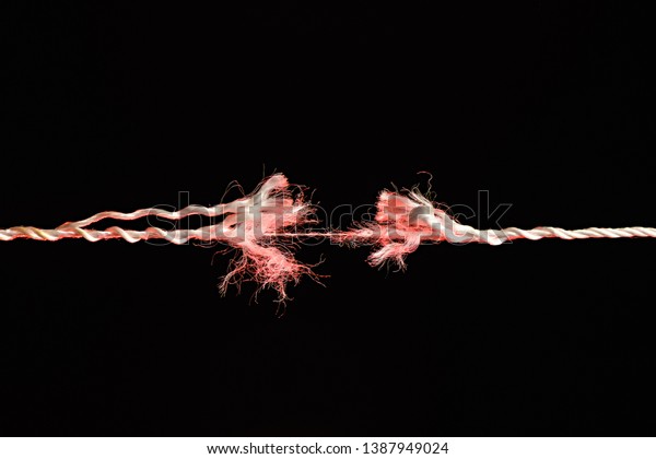 Tearing the red rope in the middle of the\
frame on black\
background
