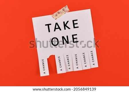Tear-off stub note with text 'Take a chance' on red background