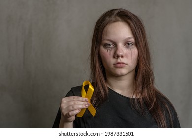 Tear-stained Teen Girl Holds Yellow Ribbon. Concept Of Suicide Problems And Their Prevention. Empty Space For Text