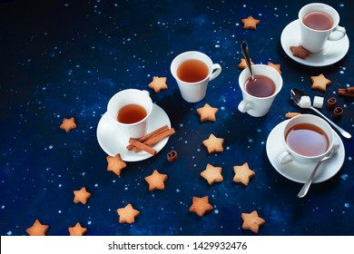 Teatime With Star-shaped Cookies. White Porcelain Cups On A Starry Sky Background. Outer Space And Astronomy Food Photography.