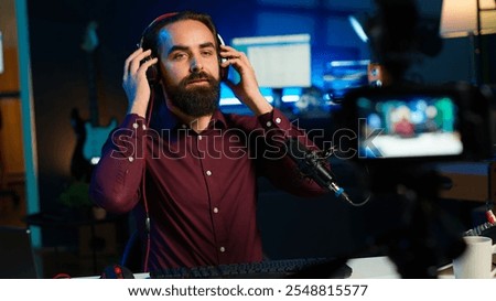 Tech expert testing headphones, mouse and keyboard, reviewing them for online streaming platforms. Internet show host presenting audio device and computer peripherals, camera A