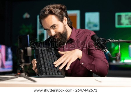 Tech guru promoting mechanical keyboard from sponsor to subscribers. Content creator paid by brand to showcase computer peripheral device with neon lit keys in home studio