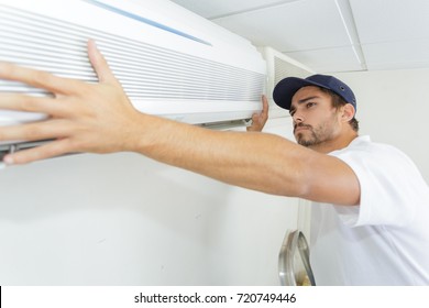 Tech Guy Carefully Installing New Ac