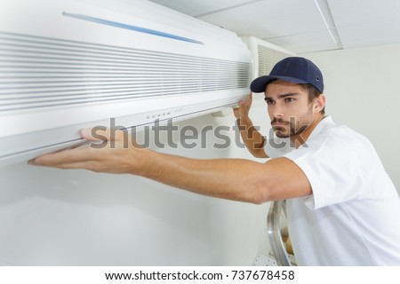 tech guy carefully installing new ac