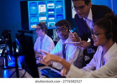 Tech support and software development team working in a modern operations center at night, reviewing mobile application UI UX grids on digital screens. - Powered by Shutterstock - Get 15% off with code: PIKWIZARD15