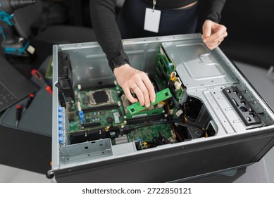 Tech worker in a server chassis upgrading RAM and components inside a desktop tower