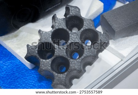 Technical component made of expanded polypropylene EPP. Black object of dense and lightweight EPP, expanded polypropylene material, universal foam. New modern technologies. Industrial manufacturing