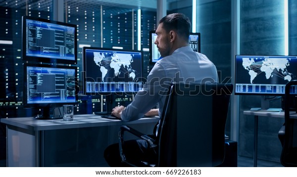 Technical Controller Working at His\
Workstation with Multiple Displays. Displays Show Various Technical\
Information. He\'s Alone in System Control\
Center.
