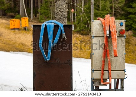 Technical distribution box and snowmaking hoses on ski slope, artificial snow system infrastructure, winter resort technical equipment, high-pressure water hoses for snow guns, skiing facility mainten