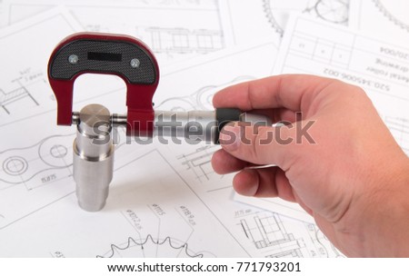 Technical drawing, micrometer and driving roller chain. Engineering, technology and metalworking. Micrometer measurement of detail of industrial chain.