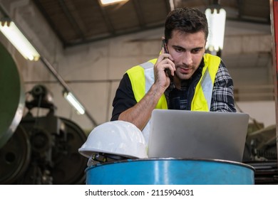 Technical engineer wearing safety vest standing in the factory workplace. Worker using smartphone and laptop talk with manager. Concentrate on job. Problem solving. Manufacturing and industrial - Powered by Shutterstock