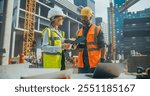 Technical Inspector Interviewing a Construction Manager on Behalf of an Occupational Health and Safety Commission. Female Specialist Using a Tablet Computer to Question a Construction Worker