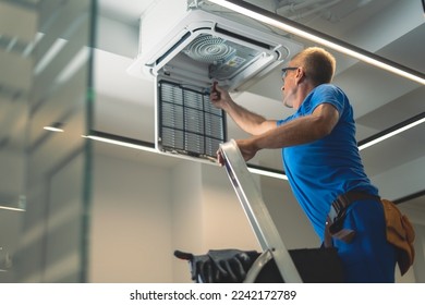 Technical maintenance worker repairs the air conditioning system - Shutterstock ID 2242172789