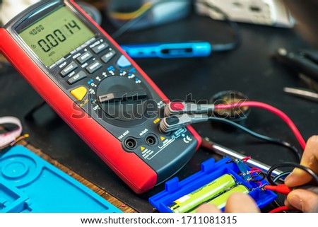 technical master tests the battery voltage. technical support, repair