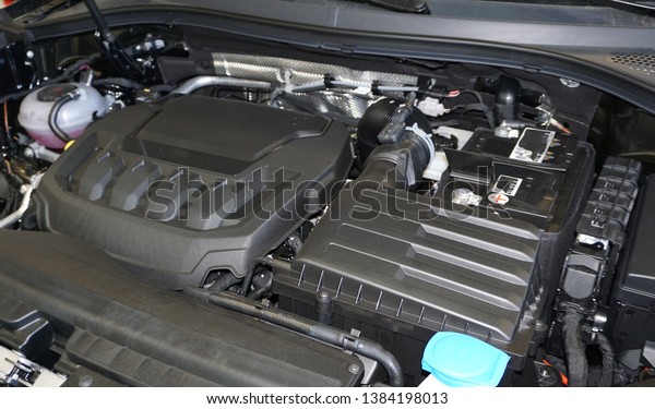 Technical photo. The internal combustion engine of a\
modern car. Structure and appearance. Intake manifold. Air filter\
housing. Accumulator battery. Expansion tank.                      \
    