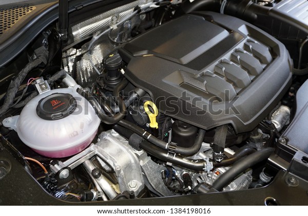 Technical photo. The internal combustion engine of a\
modern car. Structure and appearance. Intake manifold. Air filter\
housing. Accumulator battery. Expansion tank.                      \
    