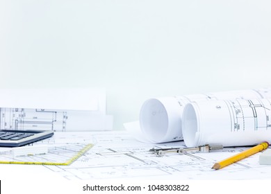 technical project plan, blueprint rolls, pencil, compass, calculator on architect desk. construction background.Â 