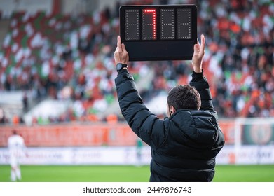 Technical referee shows added time during football match.