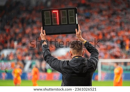 Technical referee shows added time during football match.