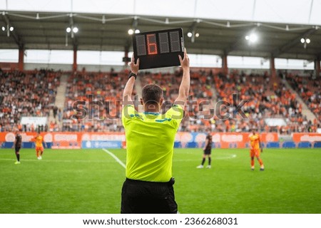 Technical referee shows added time during football match.