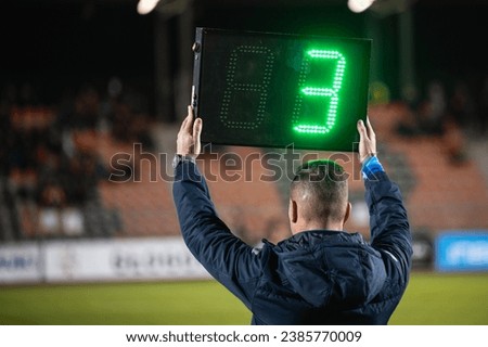 Technical referee shows added time during football match.