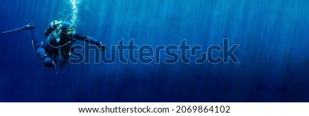 Technical scuba diver in a horizontal position with sun rays blue background. High quality photo. Can be used as a background for a banner