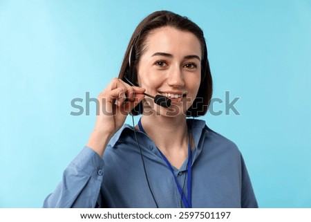 Technical support call center. Portrait of smiling operator on light blue background