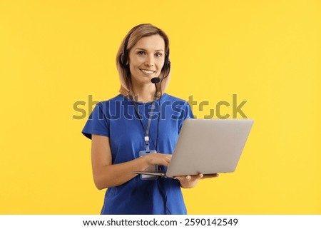 Technical support call center. Smiling operator with laptop on yellow background