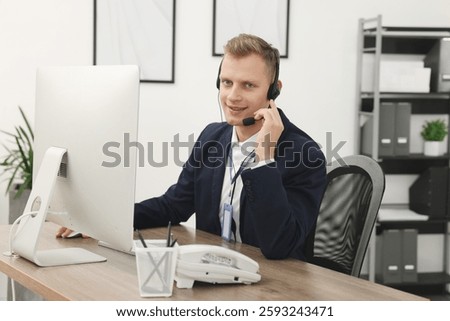 Technical support call center. Smiling operator working at table in office