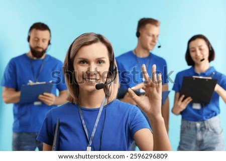 Technical support call center. Team of friendly operators on light blue background