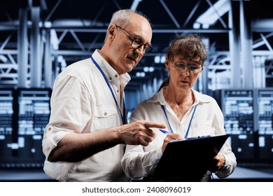 Technical support consultants fixing server system failures. Old mechanics brainstorming ideas on how to best minimize high tech data storage business downtime and prevent damage
