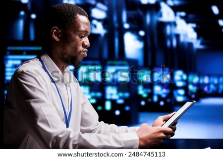 Technical support executive resolving performance related issues in data center mainframes. Manager utilizing mock up tablet to identify operational problems causing hardware slowdown