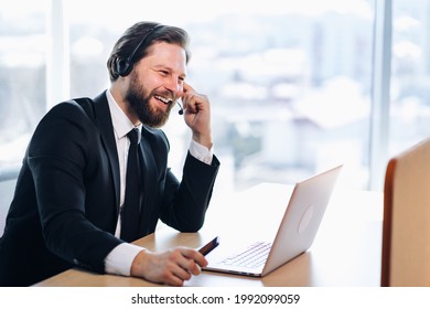 The technical support manager in the headset advises the customer. Sits in a modern office, communicates video communication.