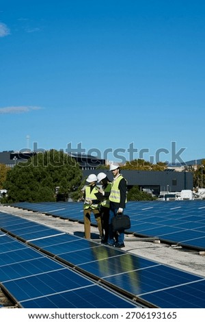 Technical team of solar engineers checking and discussing renewable energy installation on a commercial building rooftop