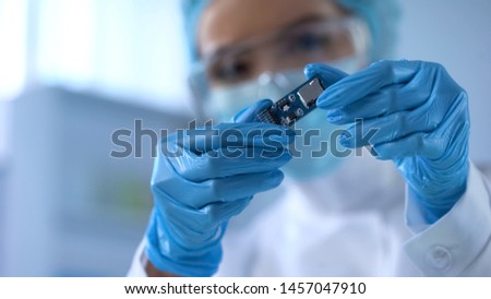 Technical worker in gloves looking at microcircuit, computer safety, technology